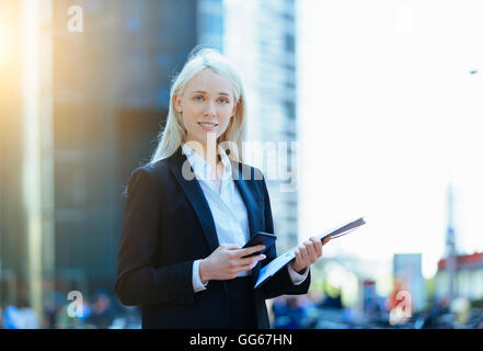 Portrait d'une femme d'aide d'un smartphone Banque D'Images