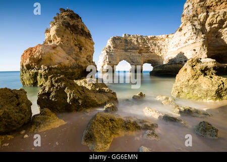 Lever du soleil sur les falaises et l'eau turquoise de l'océan, Praia da Marinha, Caramujeira, Municipalité de Lagoa, Algarve, Portugal Banque D'Images