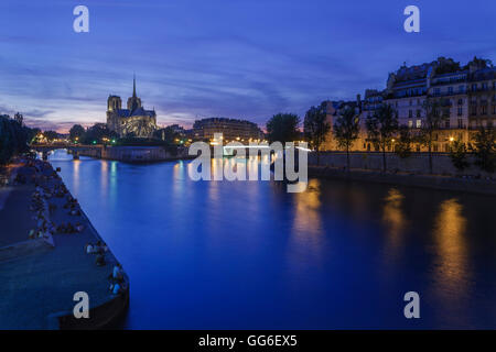 Les Parisiens et les touristes line des rives de la Seine à Notre Dame contre le ciel sur l'Ile de la Cité, Paris, France Banque D'Images