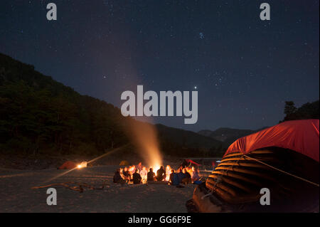 Assis autour d'un feu de camp près de la rivière Karnali au cours d'une expédition de rafting au Népal, Asie Banque D'Images