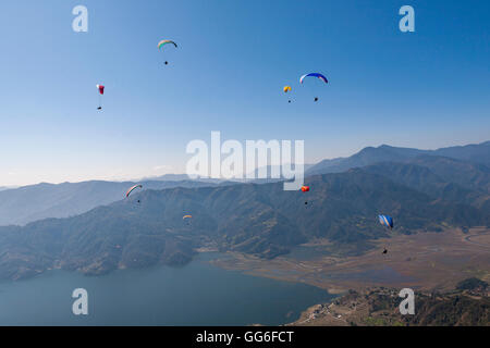 Des dizaines de parapentes profiter des vues magnifiques de l'Himalaya au-dessus du Lac Phewa, Népal, Asie Banque D'Images