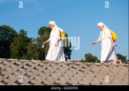 Journée mondiale de la Jeunesse 2016. Deux femmes, les pèlerins, des religieuses en habits blancs, marcher le long de la river embankment avec sacs à dos jaune Banque D'Images