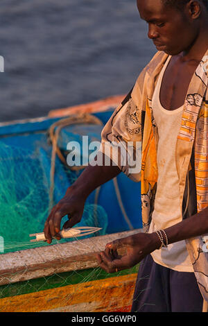 Sénégal : les hommes raccommodage des filets de pêche dans le port de pêche Ziguinchor Banque D'Images