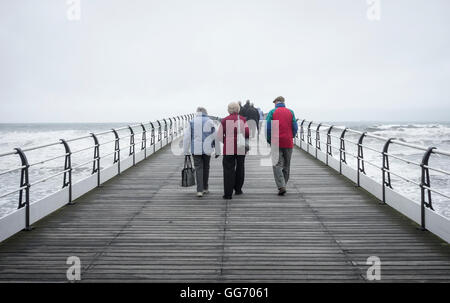 Les gens qui marchent sur Paris's Victorian pier par une froide journée d'octobre, gris. Marseille par la mer, en Angleterre. UK Banque D'Images