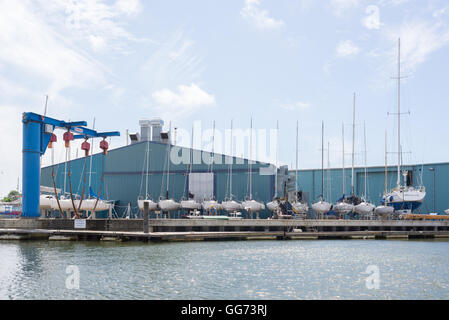 Voiliers alignés dans le chantier naval à Lymington, Hampshire, Royaume-Uni. Banque D'Images