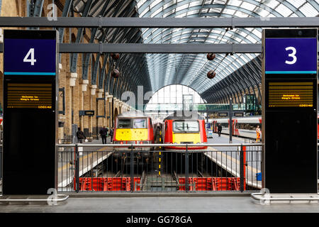 Les trains s'arrêtent sur les plates-formes dans la gare de King's Cross Banque D'Images