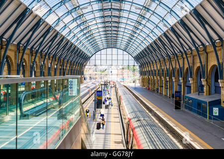 Voyageurs passent le long de plates-formes dans la gare de King's Cross Banque D'Images