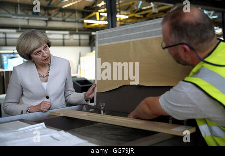 Premier ministre Theresa peut parle à un travailleur au cours d'une visite à Martek de menuiserie à New Addington, Surrey. Banque D'Images