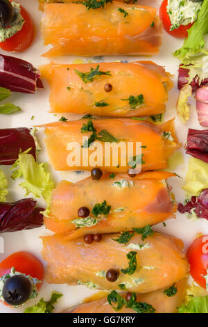 Merveilleux et délicieux rouleaux de saumon fumé avec salade de tomates et fromage olive Banque D'Images