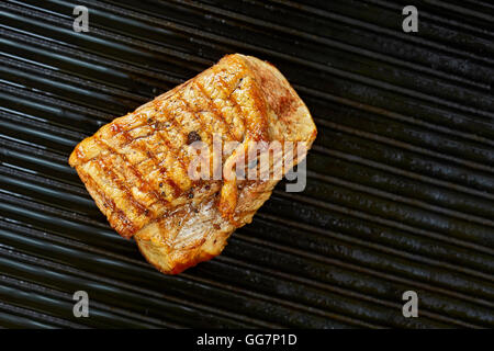 Close up photo d'une longe de porc rôti sur un pan noir. Banque D'Images