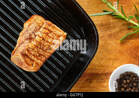 Close up photo d'une longe de porc rôtie en noir le moule sur une table en bois. Banque D'Images