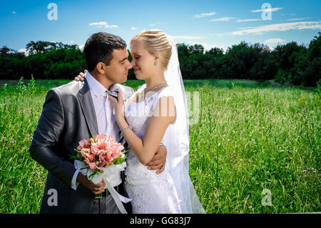 Un couple marié, l'époux et l'épouse, sur le point de baiser de soleil sur une belle ville au bord de l'eau Banque D'Images