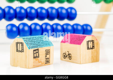 Deux miniatures de maisons en bois avec un grand comptoir en bois en arrière-plan en tant que matériel scolaire et d'aide pour les enfants, de l'enseignement Banque D'Images