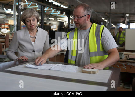 Premier ministre Theresa peut parle à un travailleur au cours d'une visite à Martek de menuiserie à New Addington, Surrey. Banque D'Images