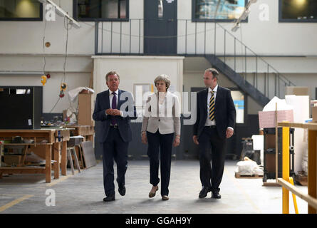 Premier ministre Theresa May avec Martek Gérant Derek Galloway (à gauche) et Croydon MP Centrale Gavin Barwell (à droite) lors de sa visite à Martek de menuiserie à New Addington, Surrey. Banque D'Images