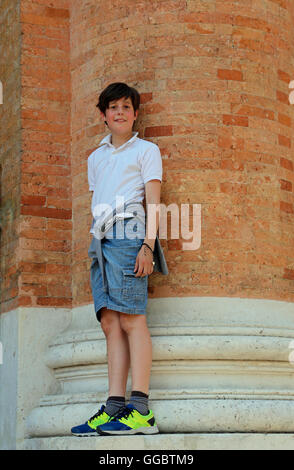 Cute Kid au-dessus de la grande colonne de briques rouges Banque D'Images