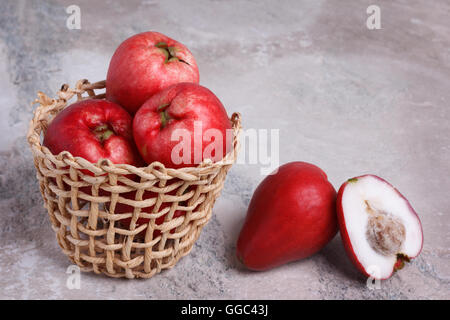 Fruits tropicaux Acmella oleracea (mal de dents, de l'usine, paracress electric daisy, le jambu) dans panier en osier sur table de marbre Banque D'Images