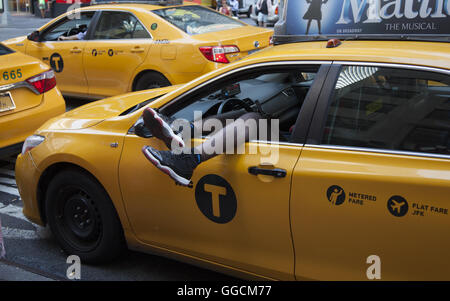 C'est chauffeur de taxi à l'arrêt de la lumière sur la 7e Avenue à Times Square sur une chaude journée d'été. NYC. Banque D'Images