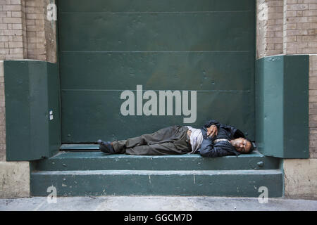 L'homme dort sur un quai de chargement dans mistown Street à Manhattan, New York City. Banque D'Images