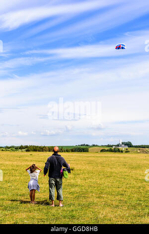 Kaseberga, Suède - août 1, 2016 : des personnes réelles dans la vie quotidienne. Man flying kite dans un champ avec un ciel en arrière-plan. Gi Banque D'Images