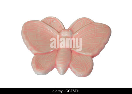 Un papillon en céramique rose sur fond blanc. Banque D'Images