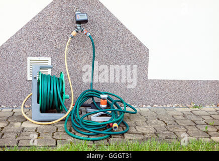 Matériel d'irrigation de jardin contre mur de la maison et prêt à l'emploi Banque D'Images