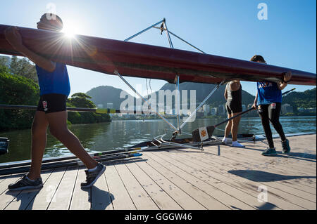 RIO DE JANEIRO - le 22 mars 2016 : Après la formation, une femme rameur brésilien porte son bateau dans le clubhouse à Lagoa. Banque D'Images