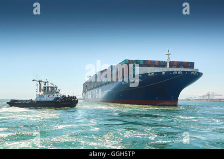 Le géant, CMA CGM Centaurus, porte-conteneurs est manoeuvré vers Pier J dans le terminal à conteneurs de Long Beach, Californie, USA. Banque D'Images