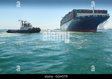 Le géant, CMA CGM Centaurus, porte-conteneurs est manoeuvré en J, à la jetée du terminal à conteneurs de Long Beach, Californie, USA. Banque D'Images