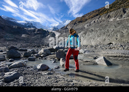 Femme traversant le glacier Morteratsch Creek, près de l'embouchure du glacier Morteratsch avec vue à Bellavista (3922 m), le Piz Bernina Banque D'Images