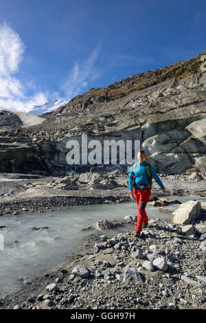 Femme traversant le glacier Morteratsch Creek, près de l'embouchure du glacier Morteratsch avec vue sur le Piz Bernina (4049 m), l'Engadine, G Banque D'Images