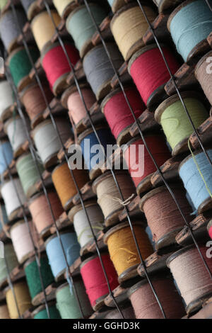 Bobines de coton de couleur stocké dans un style européen rack qui pend sur le mur Banque D'Images