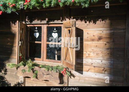 Fenêtre en bois d'un chalet de montagne décoré pour Noël. Banque D'Images