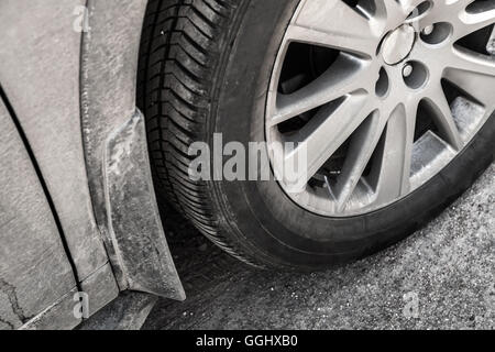 Roue de voiture non identifiables sale avec jantes disque sur route de campagne, la photo en gros Banque D'Images