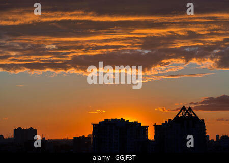 Coucher de soleil spectaculaire urbain avec plus de gratte-ciel et nuages Banque D'Images