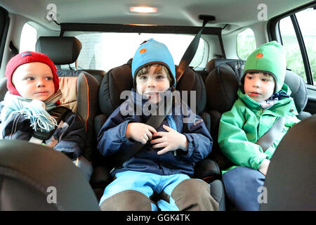 Trois enfants assis dans une voiture Banque D'Images