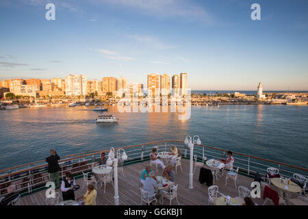 Les passagers de dîner à l'extérieur de Lido Cafe d'une croisière MS Deutschland (Peter Deilmann Reederei) au coucher du soleil, Malaga, Anda Banque D'Images