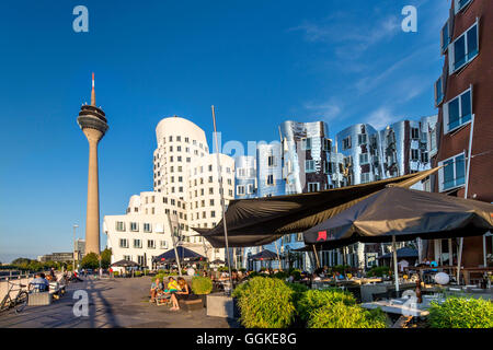 Café avec Frank Gehry buildings en arrière-plan, Neuer Zollhof, port des Médias, Düsseldorf, Rhénanie du Nord-Westphalie, Allemagne Banque D'Images