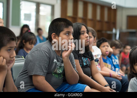 Les enfants et les parents à écouter conteur à Colorin Colorado, un programme d'été pour les personnes apprenant l'anglais dans la région de Austin TX Banque D'Images