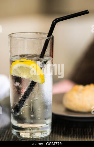 Verre de l'eau encore glacée avec une paille et de glace tranche de citron Banque D'Images