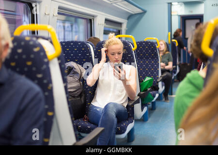 Femme à l'aide de téléphone portable en voyage en train. Banque D'Images