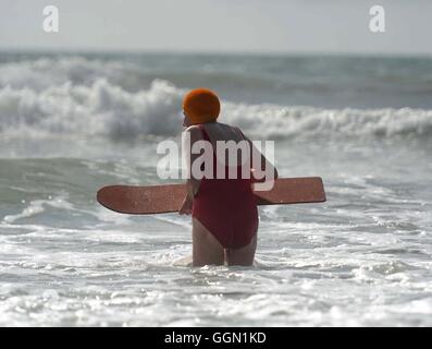 Femme âgée bénéficie d'bodyboard à la plage de Polzeath, Cornwall, UK Banque D'Images