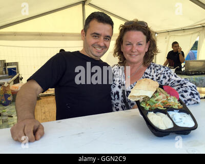 Skanderborg au Danemark. Le 05 août, 2016. Haval Zahabi ont fait état des réfugiés syriens et Lene Kjeldsen du Danish refugee aid stand à un stand de nourriture et de montrer le plat de riz Syrien 'Kabsa" au "mukfest» music festival à Skanderborg, Danemark, 05 août 2016. Photo : JULIA WAESCHENBACH/dpa/Alamy Live News Banque D'Images