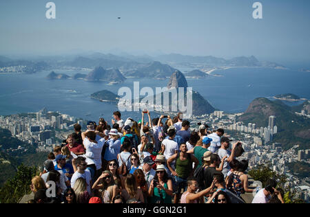 Rio de Janeiro, Brésil. 5 Août, 2016. Les gens se placer sur la plate-forme de la statue du Christ Rédempteur et prendre des photos de la pain de sucre dans le dos avant de la Rio Jeux Olympiques de 2016 à Rio de Janeiro, Brésil, 5 août 2016. Les Jeux Olympiques de Rio 2016 se tiendra du 05 au 21 août. Photo : Bernd Thissen/dpa/Alamy Live News Banque D'Images