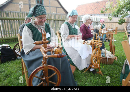 Luther, en Allemagne. Le 06 août, 2016. Les femmes s'asseoir à rouets et spin la laine des moutons comme un événement de la concurrence à la 25e journée des bergers de Thuringe en Allemagne, Luther, 06 août 2016. Ce genre de compétition professionnelle a été maintenue en Allemagne depuis plus de 100 ans. Photo : BODO SCHAKOW/dpa/Alamy Live News Banque D'Images