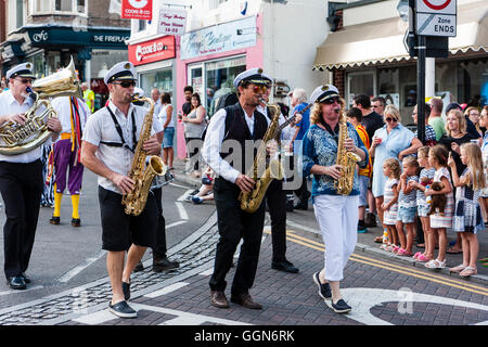 Les membres du groupe de jazz jouant saxophones en marchant et dirigeant le Boadstairs semaine folklorique défilé. Portant des costumes de la marine. Banque D'Images