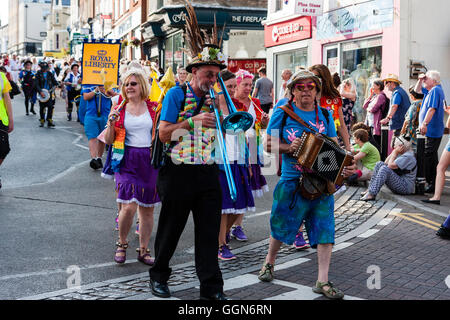 Deux hommes marchant dans la parade pour le festival de la semaine folklorique de Broadstairs marche avec l'un à l'accordéon et l'autre un trombone bleu. Banque D'Images