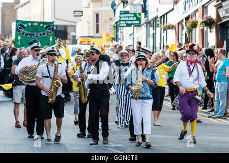 Les membres du groupe de jazz jouant saxophones en marchant et dirigeant le Boadstairs semaine folklorique défilé. Portant des costumes de la marine. Banque D'Images