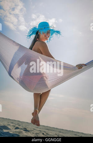Caucasian woman in hammock at beach Banque D'Images
