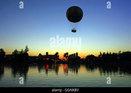Les silhouettes des bâtiments et un ballon au coucher du soleil. Banque D'Images